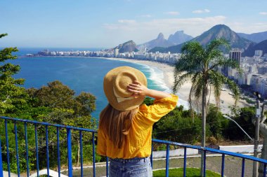 Rio de Janeiro 'da tatiller. Rio de Janeiro, Brezilya 'daki Copacabana plajının tadını çıkaran güzel gezgin kızın arka manzarası.