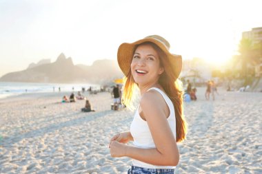 Ipanema sahilinde gülümseyen sağlıklı genç bir kadın. Rio de Janeiro, Brezilya 'da günbatımının tadını çıkaran neşeli bir kız..