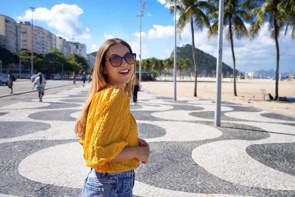 stock image Portrait of attractive smiling woman walking along Copacabana beach promenade and turns to the camera, Rio de Janeiro, Brazil