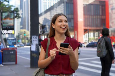 Sao Paulo, Brezilya 'da Paulista Bulvarı' nda akıllı telefon ve yüzük sahibi mutlu bir iş kadını.