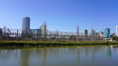 Yüksek voltajlı elektrik hatları. Brezilya 'nın Sao Paulo kentindeki Pinheiros nehrindeki Usina Elevatoria de Traicao elektrik santralinden gelen yüksek voltajlı elektrik aktarımının panoramik görüntüsü.