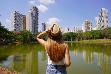 Goiania, Brezilya 'yı ziyaret ediyorum. Parque Sulivan Silvestre 'deki genç kadının arka planda kalan görüntüsü. Parque Vaca Brava olarak da bilinir. Goiania, Goias, Brezilya' da bir şehir parkı..