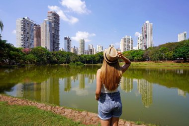 Goiania, Brezilya 'yı ziyaret ediyorum. Park Sulivan Silvestre 'deki güzel kızın arka görüntüsü. Parque Vaca Brava olarak da bilinir. Goiania, Goias, Brezilya' da bir şehir parkı..