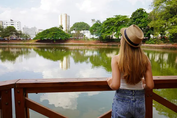 Brezilya 'da Goias State' i ziyaret ediyorum. Goiania, Goias, Brezilya 'daki Bosque dos buritis kentsel parktaki genç gezgin kadının arka görüntüsü.