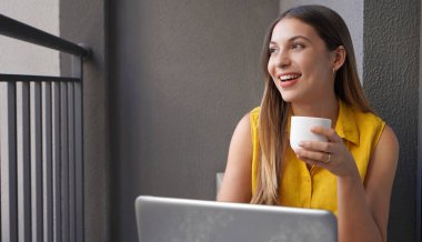 Balkonda evden çalışan yaratıcı genç bir kadın. İyi iş çıkardın. Merkez Ofis.