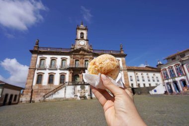 Pao de queijo (Brazilian cheese bun) in Tiradentes Square, Ouro Preto, Minas Gerais, Brazil, the city is World Heritage Site by UNESCO clipart