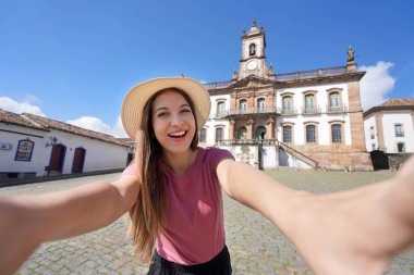 Ouro Preto, Brezilya 'daki Selfie kızı. Tiradentes Meydanı 'nda portre çeken genç turist kadın Brezilya' daki Unesco dünya mirası bölgesi Ouro Preto 'nun ünlü simgesi..
