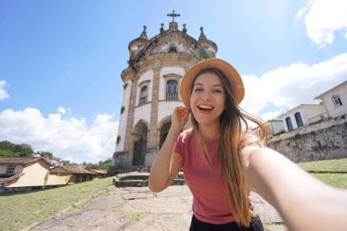 Ouro Preto, Brezilya 'daki Selfie kızı. Brezilya 'nın Minas Gerais kentindeki UNESCO' nun Ouro Preto turistik merkezindeki Our Lady of the Lady of the Rosary kilisesinin kendi portresini çeken genç turist kadın..