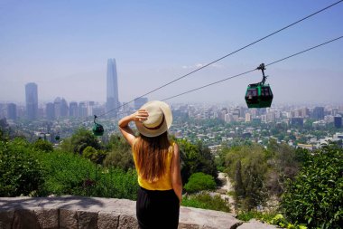 Santiago de Chile 'de turizm. Santiago Metropolitan Park, Şili 'deki teleferiklere bakan gezgin kadının arka görüntüsü.