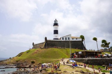 SALVADOR DE BAHIA, BRAZİL - 13 Ekim 2024: Farol da Barra deniz feneri ile Forte de Santo Antonio da Barra kalesi, Salvador de Bahia, Brezilya
