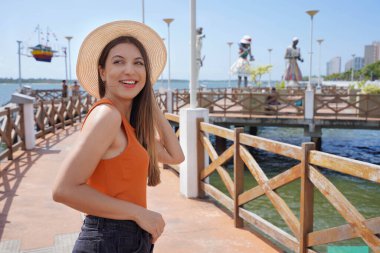 Holidays in Aracaju, Brazil. Beautiful smiling woman walking on promenade Largo da Gente Sergipana in Aracaju, Sergipe, Brazil. clipart