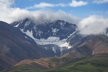 Alaska 'da Karlı Dağlar ve Bulutlu Gökyüzü.