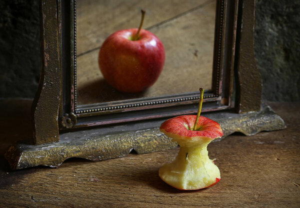 Сюрреалистичное изображение с отражением яблока в зеркале. Высокое качество фото.