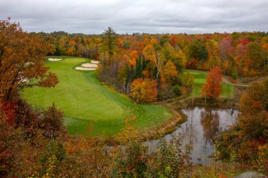 Sonbahar renkli ağaçlar ve Kanada 'nın Muskoka kentindeki göl manzaralı golf sahası. 