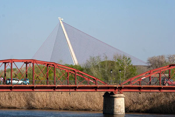 前景には鉄の橋 背景にはタガス川に架かるケーブルの橋が架かっていた — ストック写真
