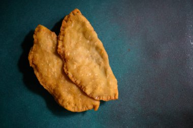 Yeşil arka planda Cheburek. Et ve soğanlı kızarmış turta. Geleneksel Türk, Moğol, Doğu Tatar, Kafkas mutfağı. Yukarıdan bak. Boşluğu kopyala.