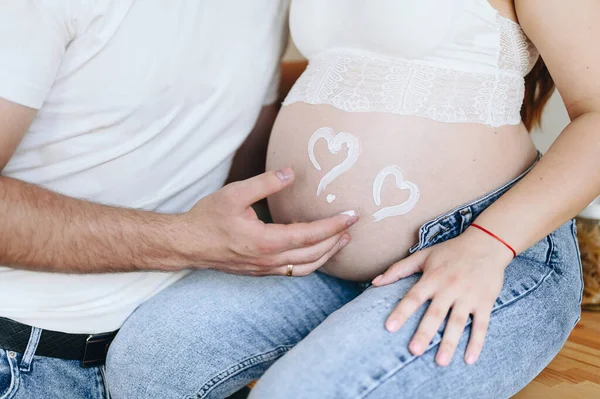 母親と健康の概念 男は彼の妊娠中の妻の腹に心臓シンボルを描画します 誠実な愛 — ストック写真