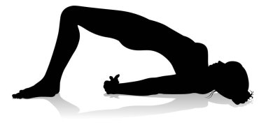 Yoga yapan ya da pilates yapan bir kadının silüeti.