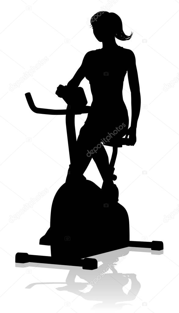A woman in silhouette using a stationary exercise spin bike piece of gym equipment fitness machine