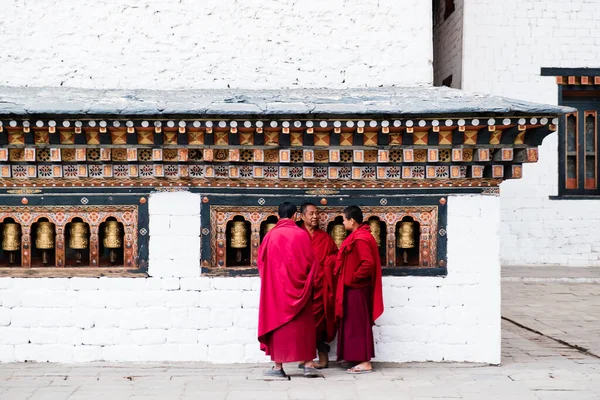 2018年12月3日 普纳卡 三名佛教学生僧侣站在不丹 普纳卡 Chimi Lhakang修道院的宗教祷告轮旁边 高质量的照片 图库图片