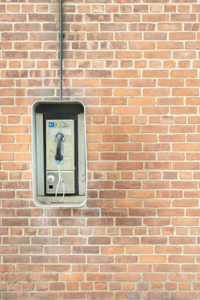 Telefonzelle Vor Einem Backsteinhintergrund Hochwertiges Foto lizenzfreie Stockfotos