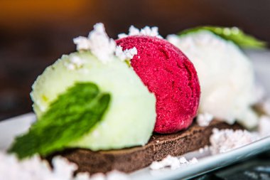 Dondurma topları ve tabakta nane yaprağı. Kapat.