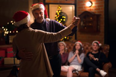 Mutlu noeller ve Amerikan ailesinin yeni yıl partisi evdeki kanepede dans ederek oturun, aile ferdi evinizde afiyet olsun.