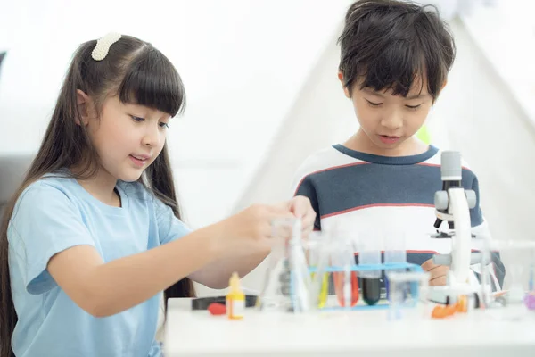 亚洲女孩和男孩通过在自家客厅里做化学实验来做家务 这张照片可用于教育 学校和学生的概念 — 图库照片