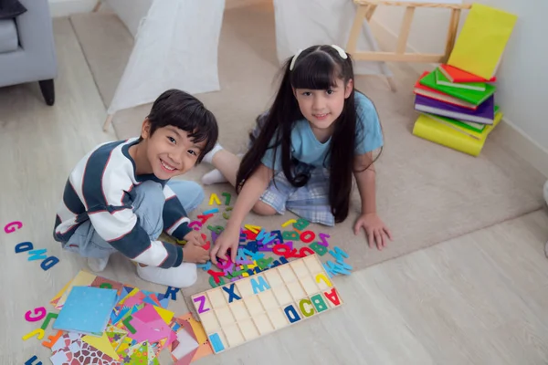 アジアの男の子と女の子の遊びと教育一緒にリビングルームで 彼らは就学前の教室で一緒にテキストブロックを再生します — ストック写真