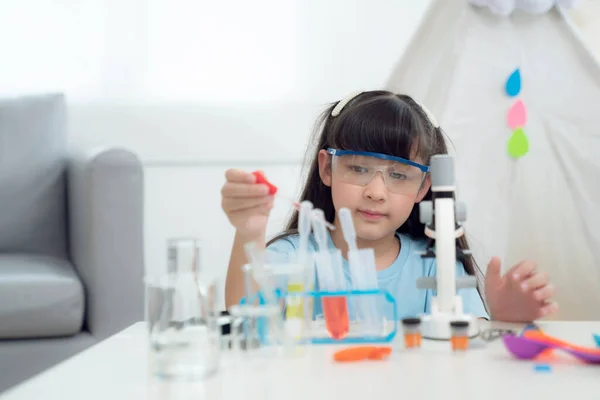 自宅のリビングルームで化学実験をするアジアの少女この写真は 学生の概念に使用することができます — ストック写真