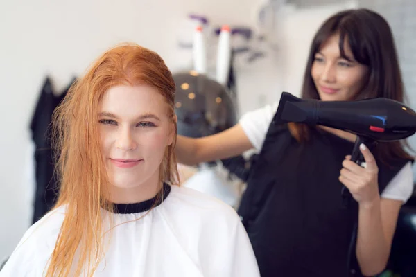 European woman hairdresser in beauty salon cut hair and hair design to her customer