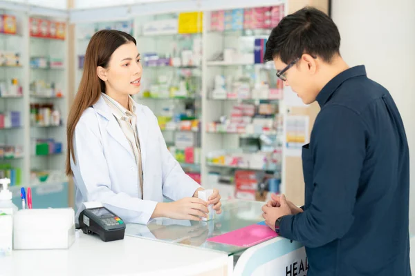 薬局のアジア人薬剤師の女性顧客と薬や薬局を販売するための彼女のビジネス — ストック写真