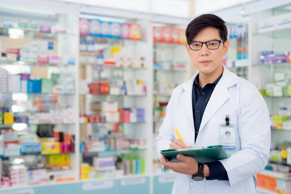 薬局のアジア人薬剤師の男性が薬と薬局を販売するための彼女のビジネス — ストック写真