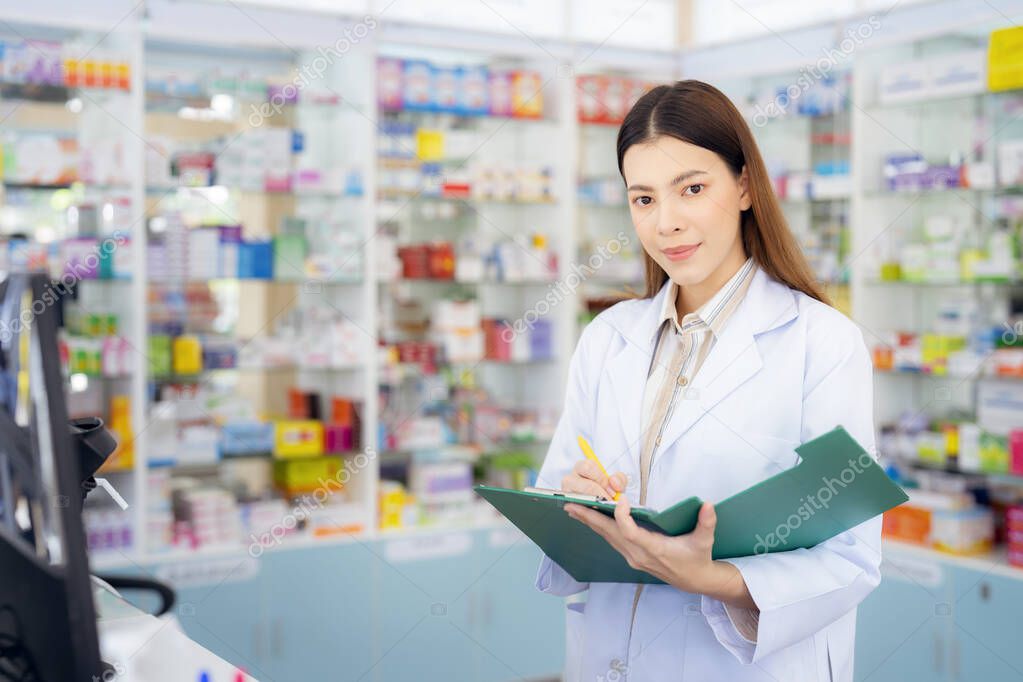 Asian pharmacist woman in pharmacy store of her business for sale a drug and pharmacy