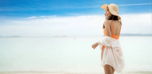 Asian tourist woman in orange bikini on the beach at Phi Phi island in Phuket, Thailand