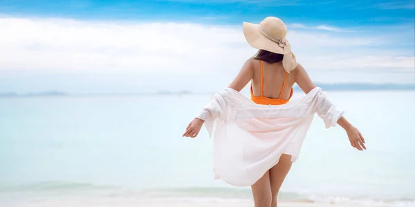 Asian tourist woman in orange bikini on the beach at Phi Phi island in Phuket, Thailand