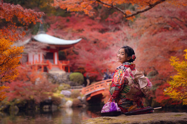 Asian traveler girl in Kimono traditional dress walking in old temple in Autumn season in Kyoto city, Japan