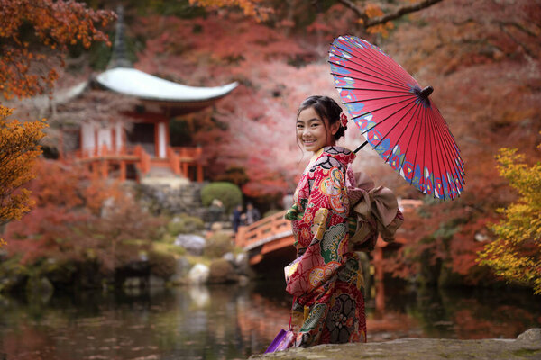Asian traveler girl in Kimono traditional dress walking in old temple in Autumn season in Kyoto city, Japan