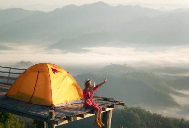 Asyalı gezgin kadın kamerasıyla Tak 'taki mon Kalakojo' nun tepesinde sabah vakti gün doğumu ve sisli arka planda, Tayland 'ın Chiang Mai kentinde kış mevsimi görüş açısı olan bir fotoğraf çekiyor.