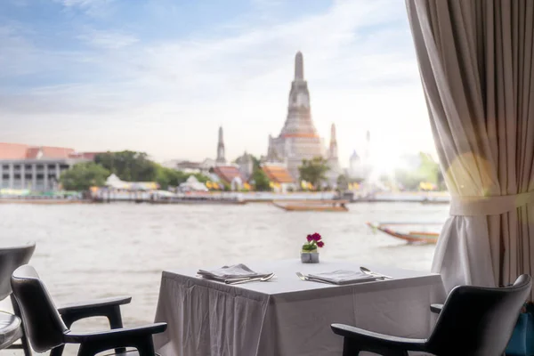 タイのバンコク市内にあるワット アルン パゴダと寺院を背景にしたレストランでのディナーテーブル — ストック写真