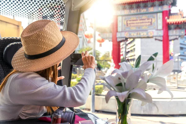 亚洲女人坐着餐馆巴士在曼谷的亚欧瓦拉特路上旅行和游览 并用她的智能手机拍照 — 图库照片