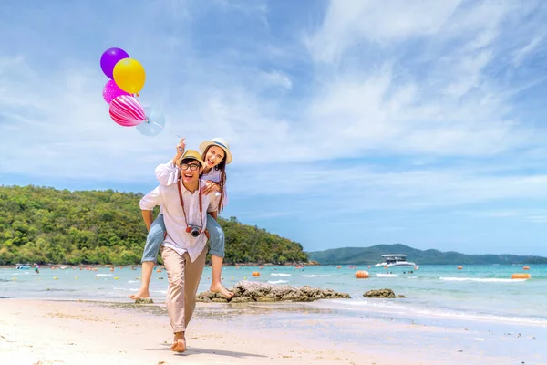 在暑假期间 一对亚洲夫妇在泰国海滩观光 并在海滩上气球 — 图库照片