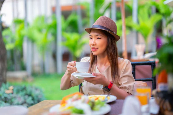 アジアの旅行者の女性は 屋外ゾーンのホテルレストランでコーヒーとサラダとビュッフェ式朝食を食べる — ストック写真