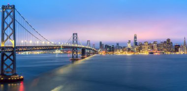 San Francisco ve Körfez Köprüsü 'nün Kaliforniya, ABD' den renkli günbatımlı şehir manzarası