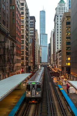 Binalar arasındaki Loop, Glass and Steel köprüsündeki yüksek raylarda tren, Chicago City Center, Chicago, Illinois, ABD