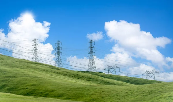 蓝色天空和绿色草地的全景上的电线杆网 — 图库照片
