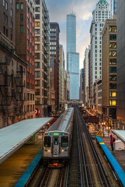 Binalar arasındaki Loop, Glass and Steel köprüsündeki yüksek raylarda tren, Chicago City Center, Chicago, Illinois, ABD