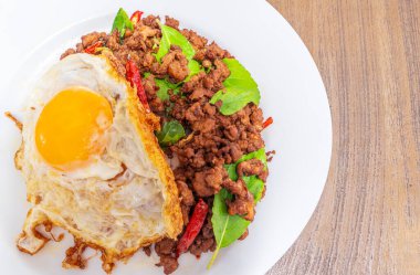 Fesleğenli pilav, beyaz tabakta yumurta, yiyecek teslimatı uygulamasından sipariş, nolin siparişi Tayland geleneksel yemek başvurularından.