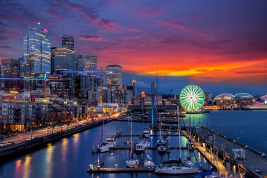 Seattle rıhtımının güzel manzarası ve mavi saatte ufuk çizgisi. Marina 66. rıhtımda, büyük tekerlek, dönme dolap, seyahat ve kentsel mimari arka plan..