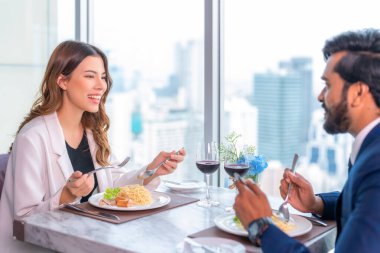 Arap çiftler çıkıyorlar ve otelin çatısındaki İtalyan restoranında masanın üstünde spagetti ile bir şeyler yiyorlar.